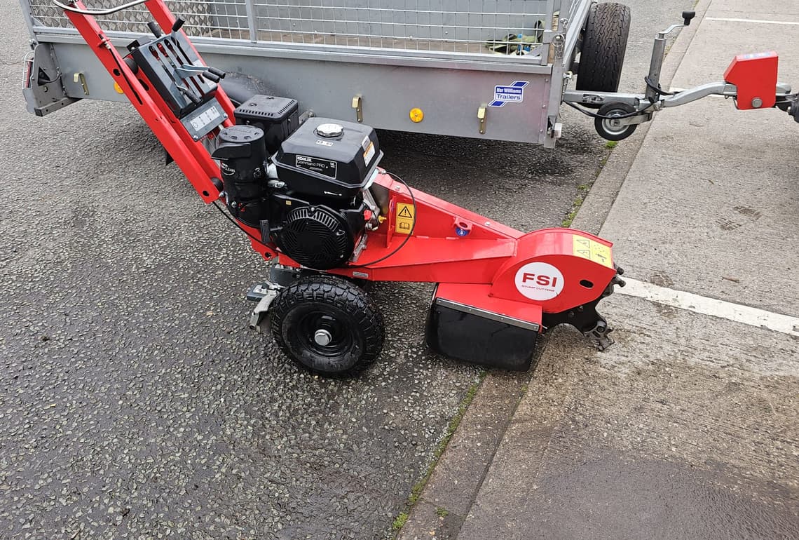 An FSI pedestrian grinder beside the Ifor Williams caged trailer it goes out on.