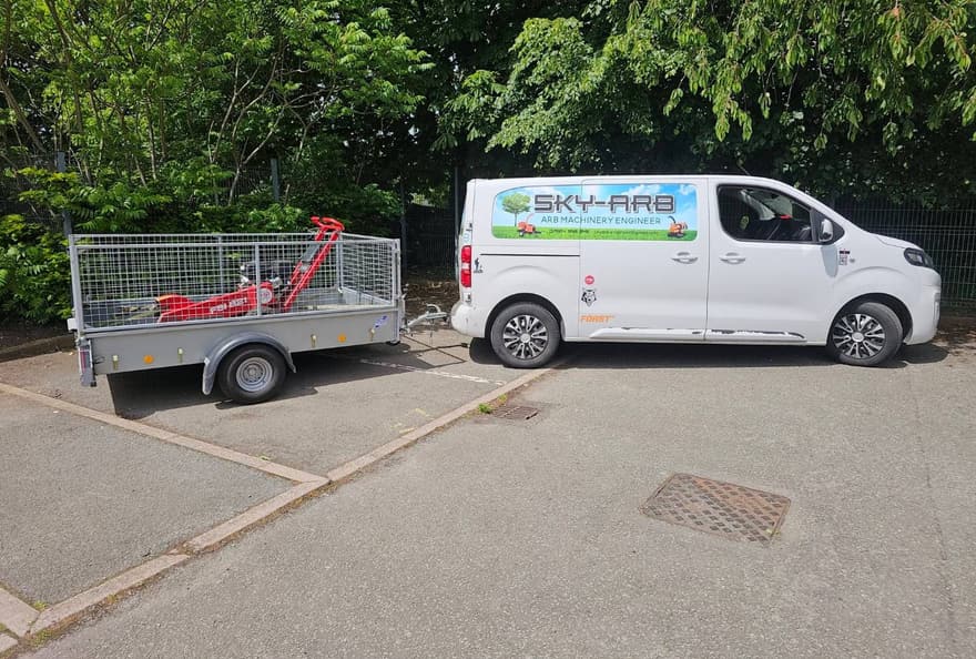 Loaded and off: the van and caged trailer with a stump grinder on.